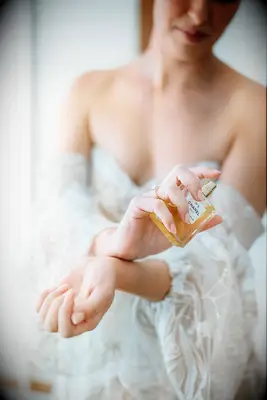 Bride spraying perfume on her wrists