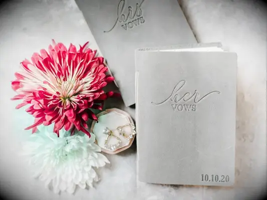 gray velvet vow books beside fresh chrysanthemum flowers