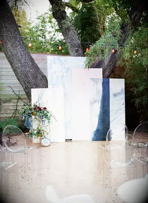 outdoor wedding ceremony altar with unique backdrop made from light pink and blue rectangular panels in different sizes