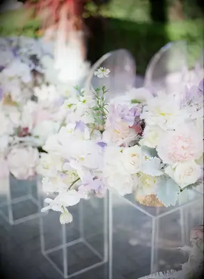 pastel wedding flower arrangements with pink peonies, purple sweet peas, white orchids and dusty miller on acrylic rectangular stands