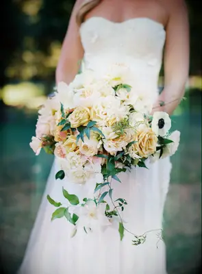 pale yellow wedding bouquet with garden roses, peonies and white clematis vines