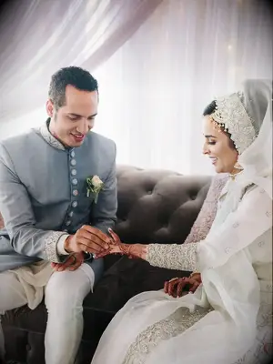 Elegant bride and groom during Muslim ring exchange tradition.