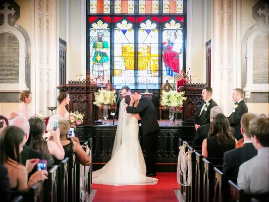 Bride and groom have their first kiss during Unitarian Universalist ceremony order for wedding.