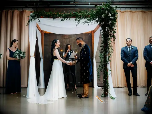 Bride and groom having an interfaith ceremony beneath a draped mandap.