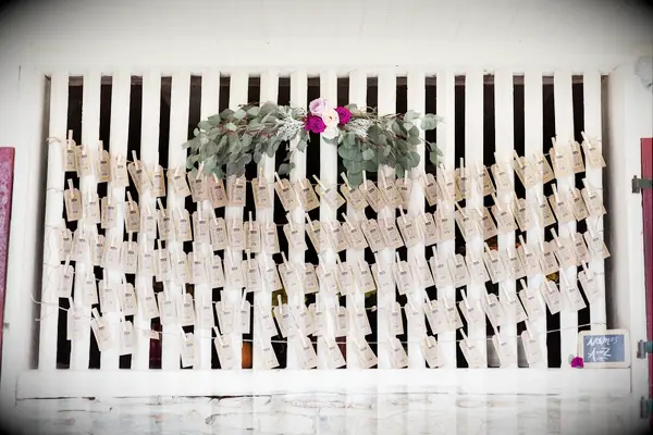Rustic escort card display with a bohemian floral arrangement. 