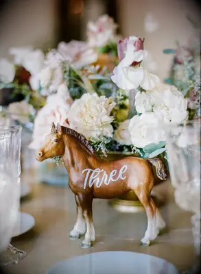 Cute horse figurine on a dining table with a number written on its side. 