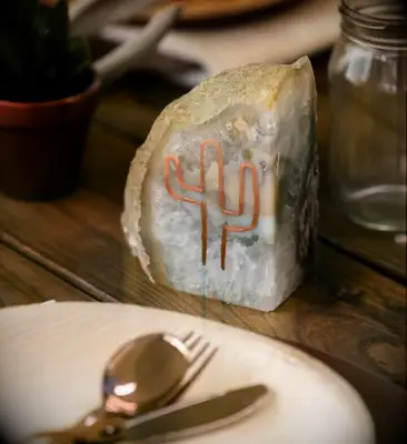 Rustic geode centerpiece with a bronze cactus outlined on the side. 
