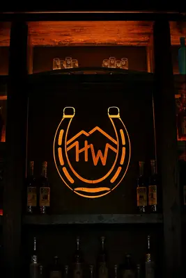 Gold horseshoe-shaped monogram in the center panel of a bar. 