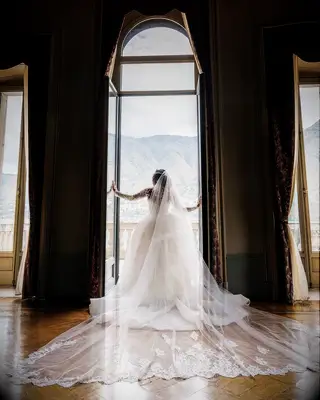 Bride in Cathedral-Length Veil at Window at Lake Como Wedding Venue