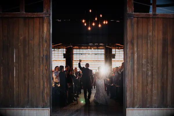 bride and groom walking into barn wedding reception venue