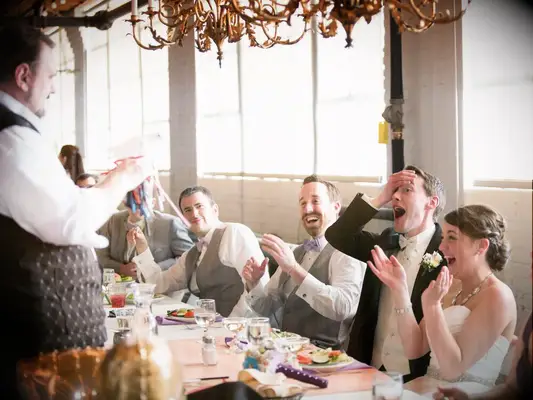 Magician performing for bride and groom as a form of wedding entertainment. 