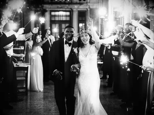 Bride and groom exiting wedding reception with sparklers