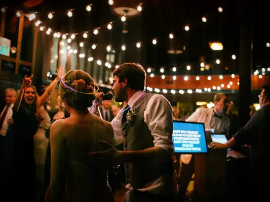 Bride and groom doing karaoke as a wedding reception activity. 