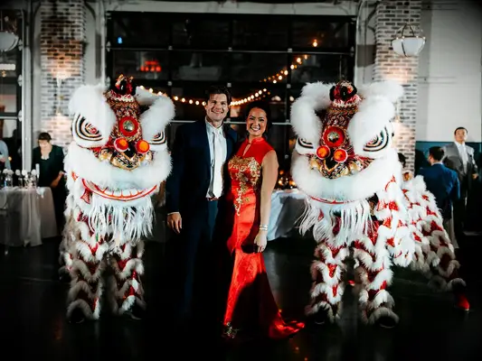 Bride and groom with cultural Chinese lion dancers at wedding reception