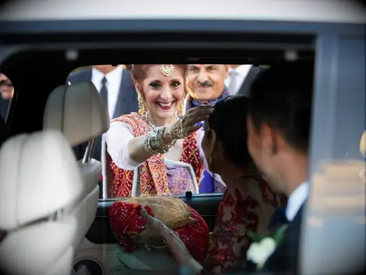 Mother of the bride wishing couples goodbye from car window
