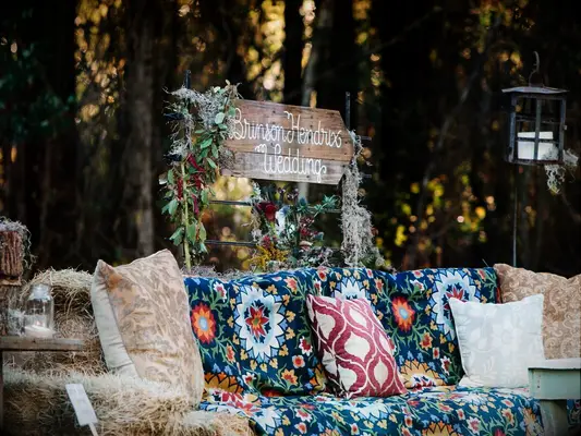 Rustic hay bale seating area at backyard wedding