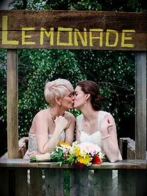 Wooden lemonade stand at backyard wedding