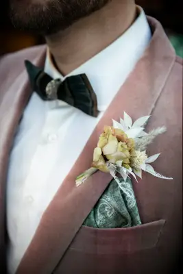 Pale pink jacket with golden and green boutonniere