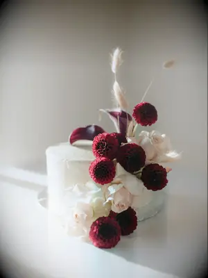 Gorgeous dark red dahlia and white rose wedding cake