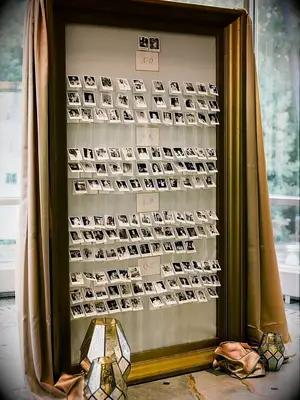 escort card wall with photographs of wedding guests
