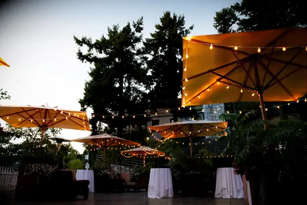 courtyard with cocktail tables and cloth umbrellas decorated with bistro string lights 