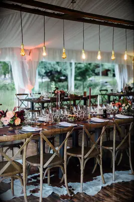 long wedding reception table with a row of edison bulb lights hanging above