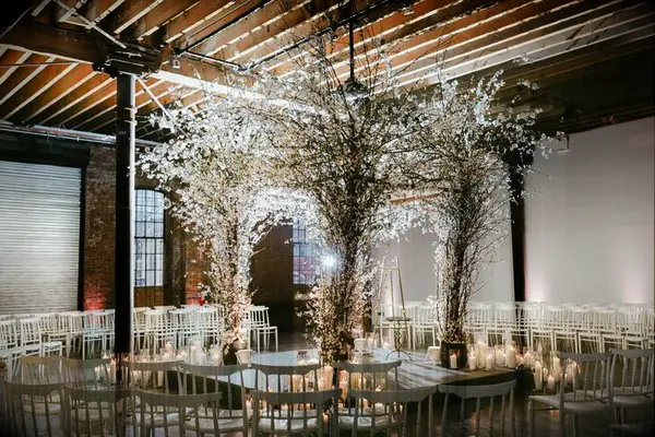 Chuppah decorated with flowering branches at industrial loft wedding ceremony
