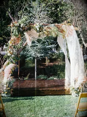 Greenery chuppah with fabric drape accents.