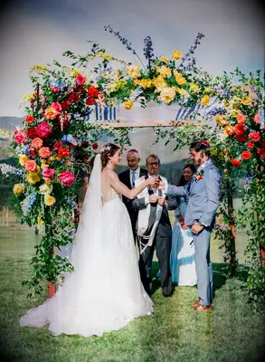 Couple under colorful chuppah at Jewish wedding in Colorado