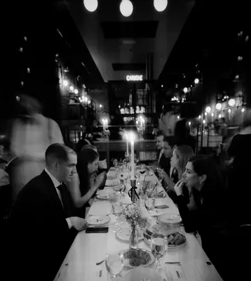 Blurry black and white wedding photo of reception dinner