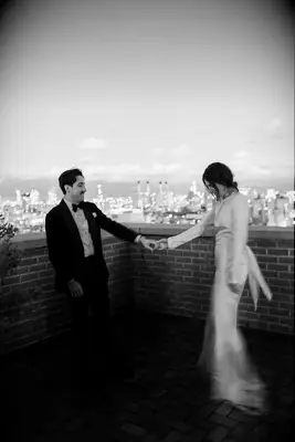 Blurry black and white wedding photo of bride and groom holding hands