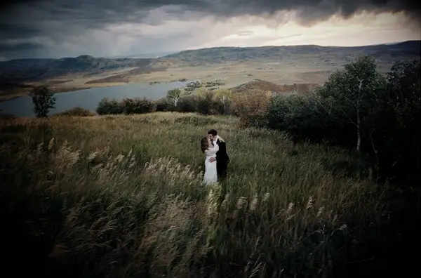 Blurry wedding photo of bride and groom hugging in field