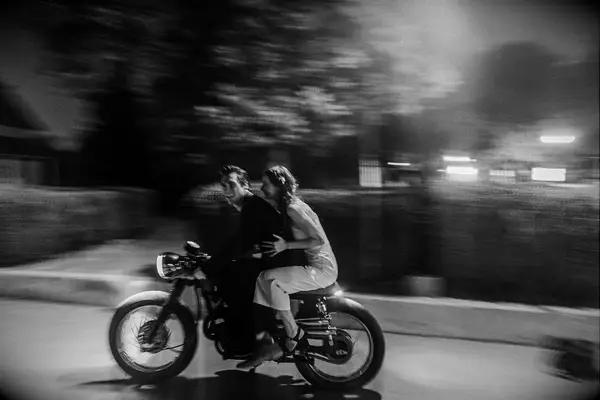 Blurry photo of bride and groom on motorcycle