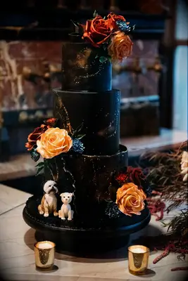 Gothic black tiered wedding cake with orange florals