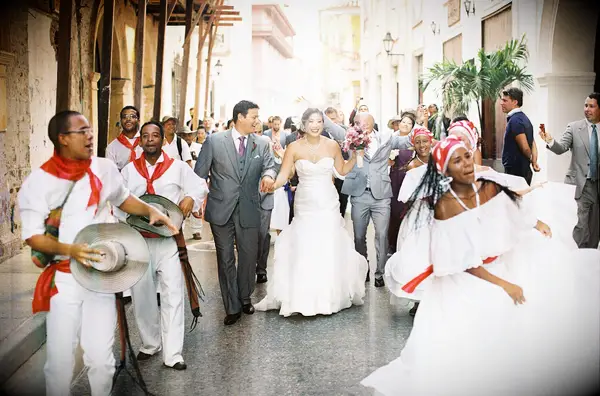 Bride and groom dancing in a parade in the street. 