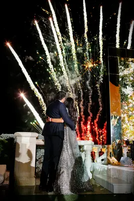 Bride and groom watch large wedding firework display. 
