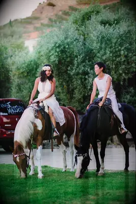 Brides riding horseback for their reception grand entrance. 