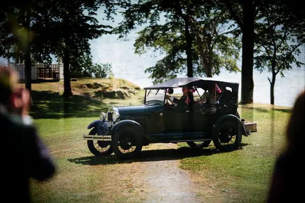 Bride and groom riding in a black vintage car. 