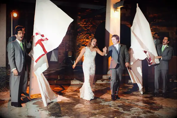 Bride and groom walk through paper banner. 