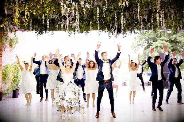 Bride and groom dancing with wedding party at the reception.