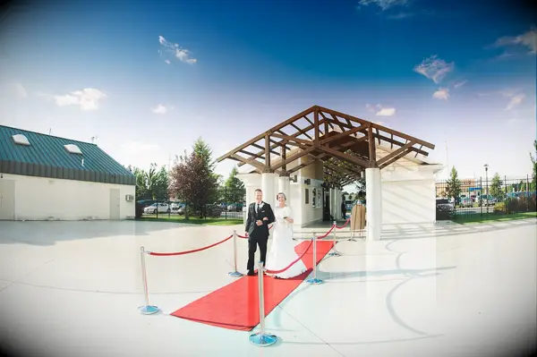 Bride and groom walking down a red carpet.
