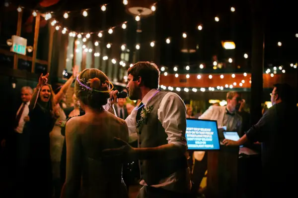 Bride and groom singing karaoke with their guests.