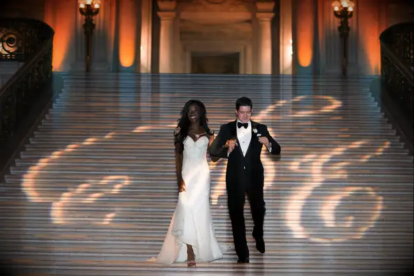 Bride and groom walking down grand staircase. 
