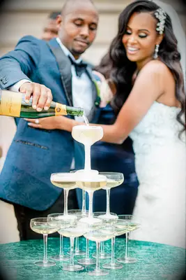 Bride and groom pouring champagne for a champagne tower. 