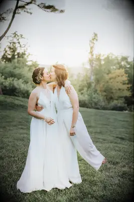 Same-sex couple wearing white wedding outfits