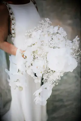 Cascading white wedding bouquet with orchids and baby