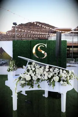 White piano filled with white roses, hydrangea and calla lilies 