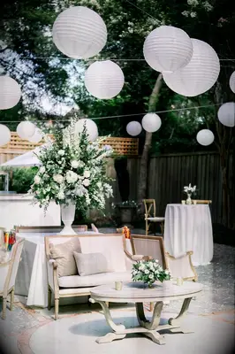 Backyard cocktail hour with lounge furniture and paper lanterns