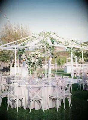 Outdoor wedding reception with neutral color palette and greenery