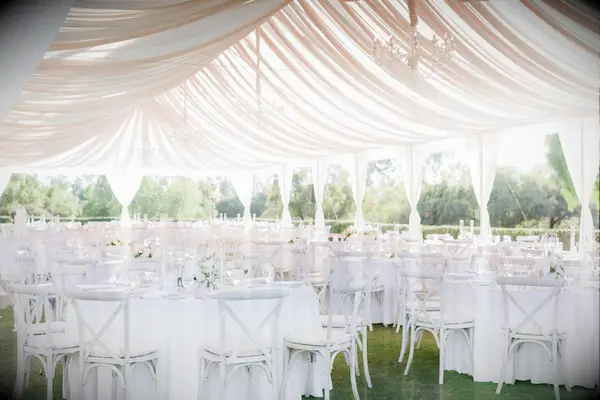 Tented wedding reception with draping and white decor